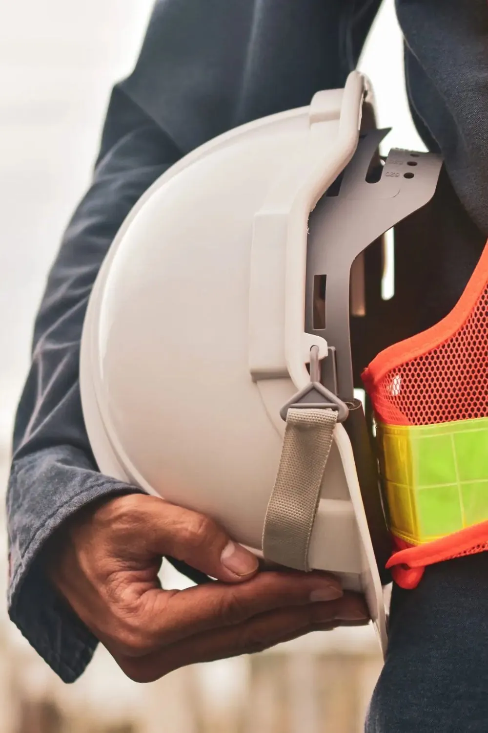 Profissional de obra segurando o capacete de segurança